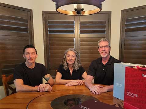 Dealership owners sitting at a table with Hunter Douglas branded cases