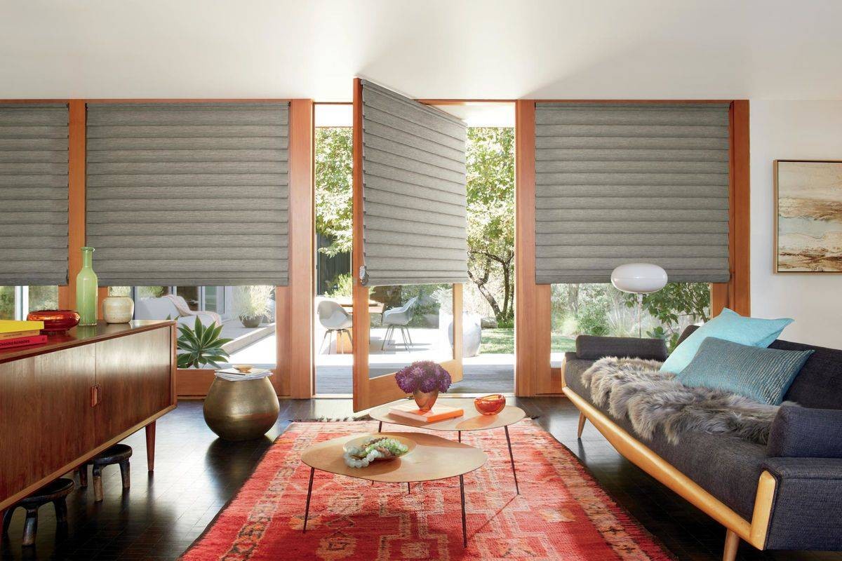 Living room with sliding doors adorned with Hunter Douglas Vignette® Roman Shades at Affordable Blind Solutions near El Dorado, CA