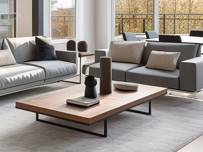 Living room area with two loveseat gray modern sofas with a oak wooden coffer table that has black metal legs.